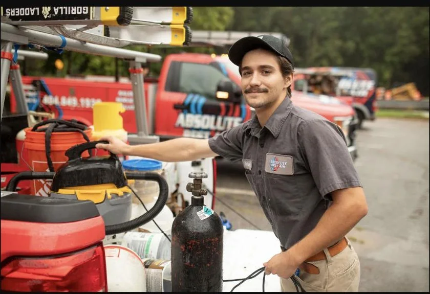 Absolute Best Air team member preparing equipment beside a service vehicle